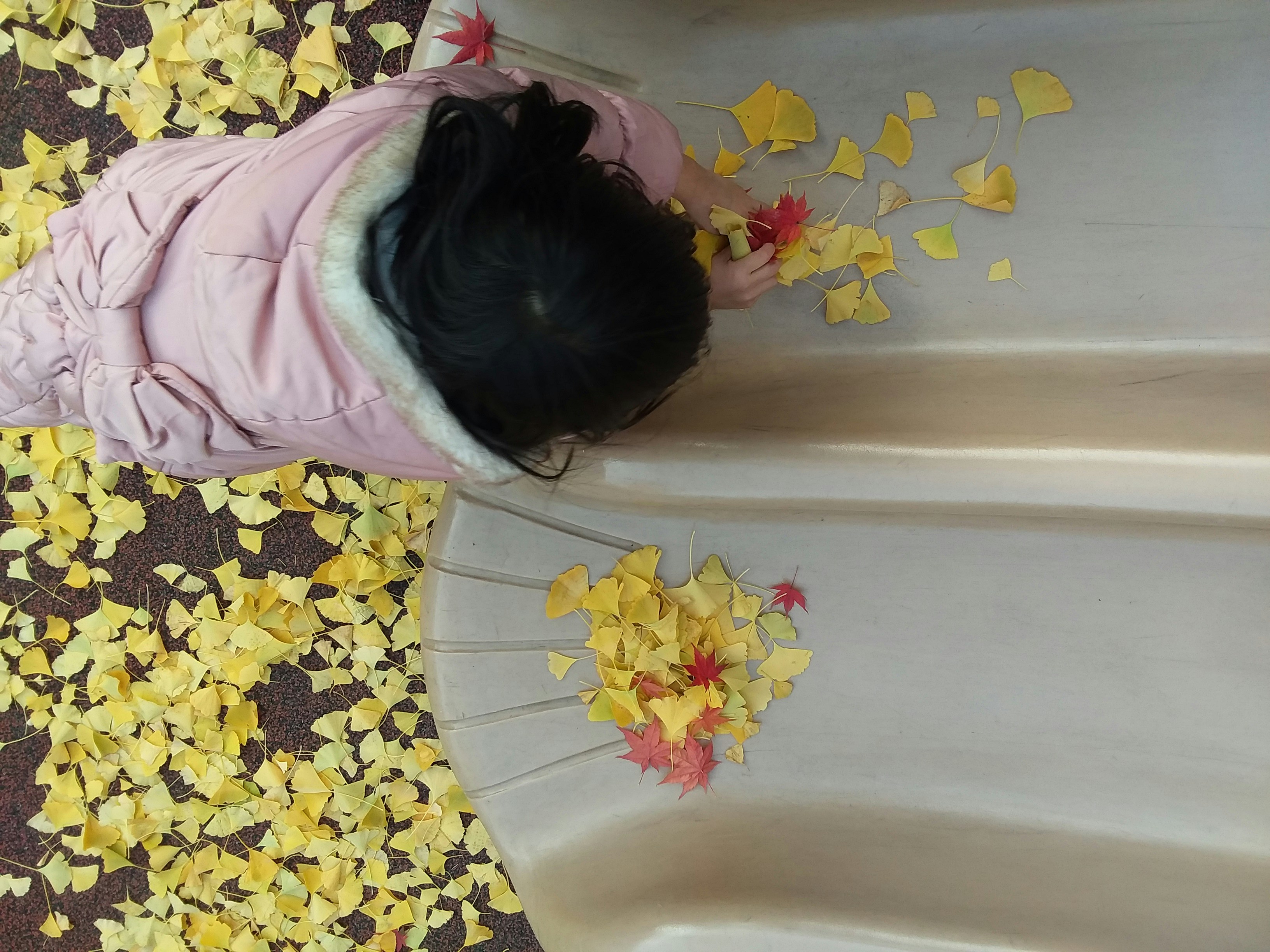 Child playing calmly with a sensory bin filled with rice and small toys, hands immersed in the texture