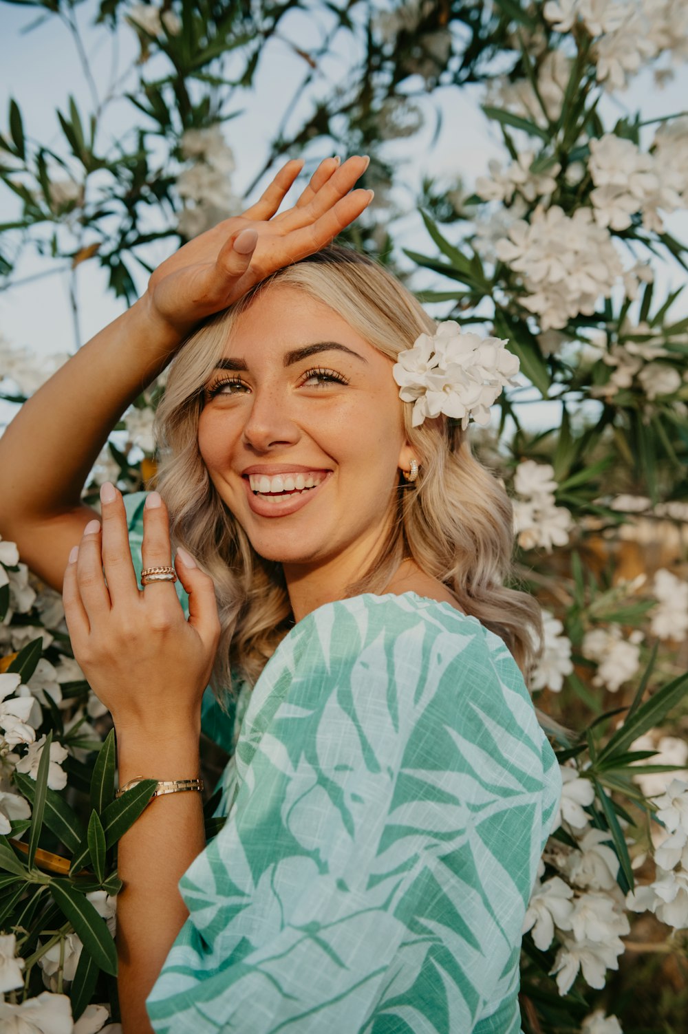 a woman smiling with her hand up