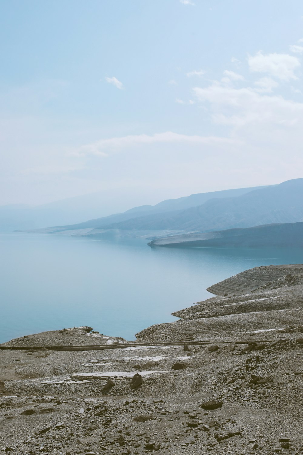 a rocky beach with a body of water in the background