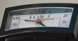 A coloring page showing a clock with smiling faces to help kids learn telling time.