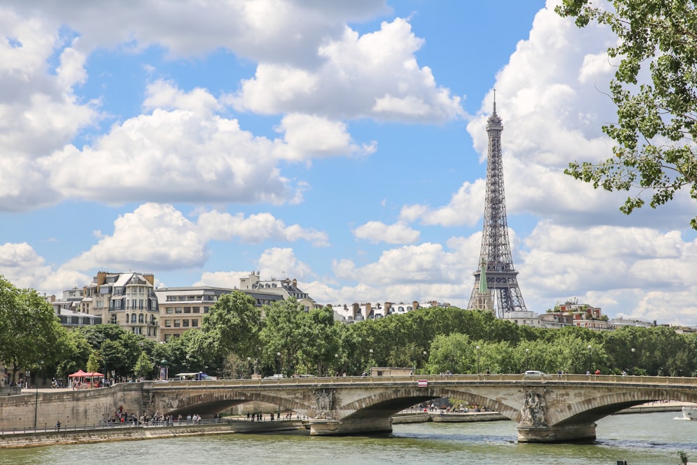 a bridge over a river with a tower in the background