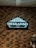 A decorative sign with elegant designs presents the name 'Deskanso Café' in illuminated letters. The sign is mounted on a brick wall, adding to a rustic and cozy ambiance.