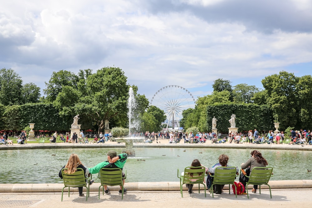 people sitting in chairs in front of a fountain