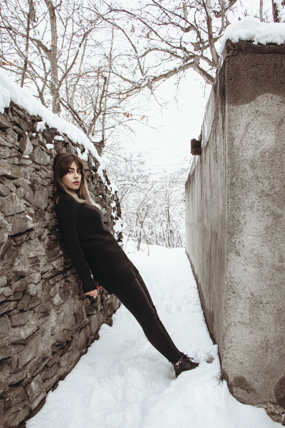 a person leaning against a stone wall