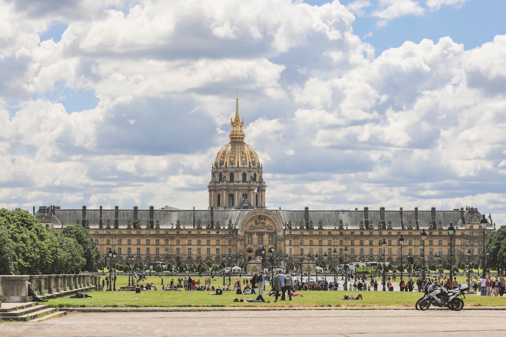 a large building with a gold domed roof and a crowd of people with Les Invalides in the background