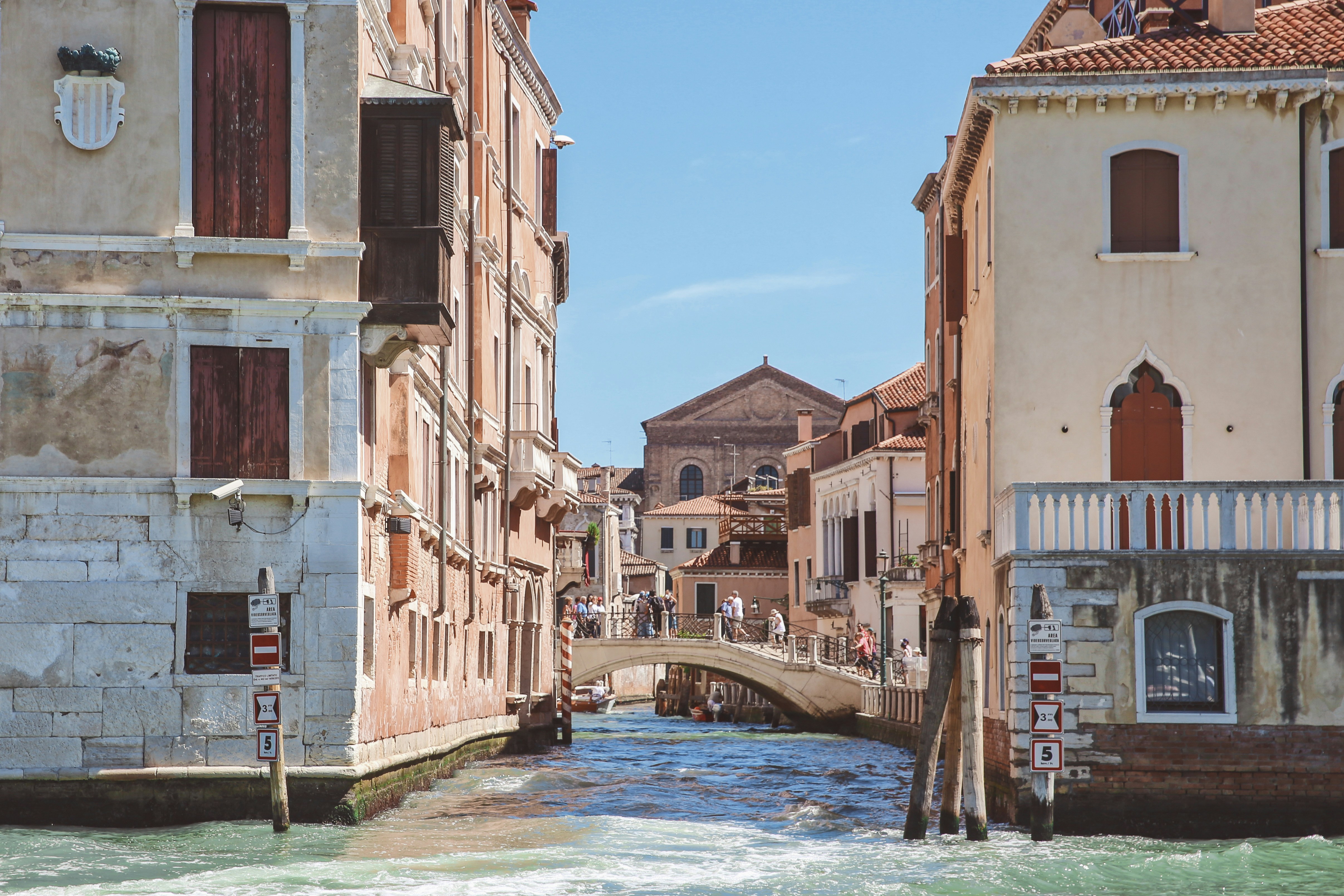 A bridge over a canal in Venice between buildings