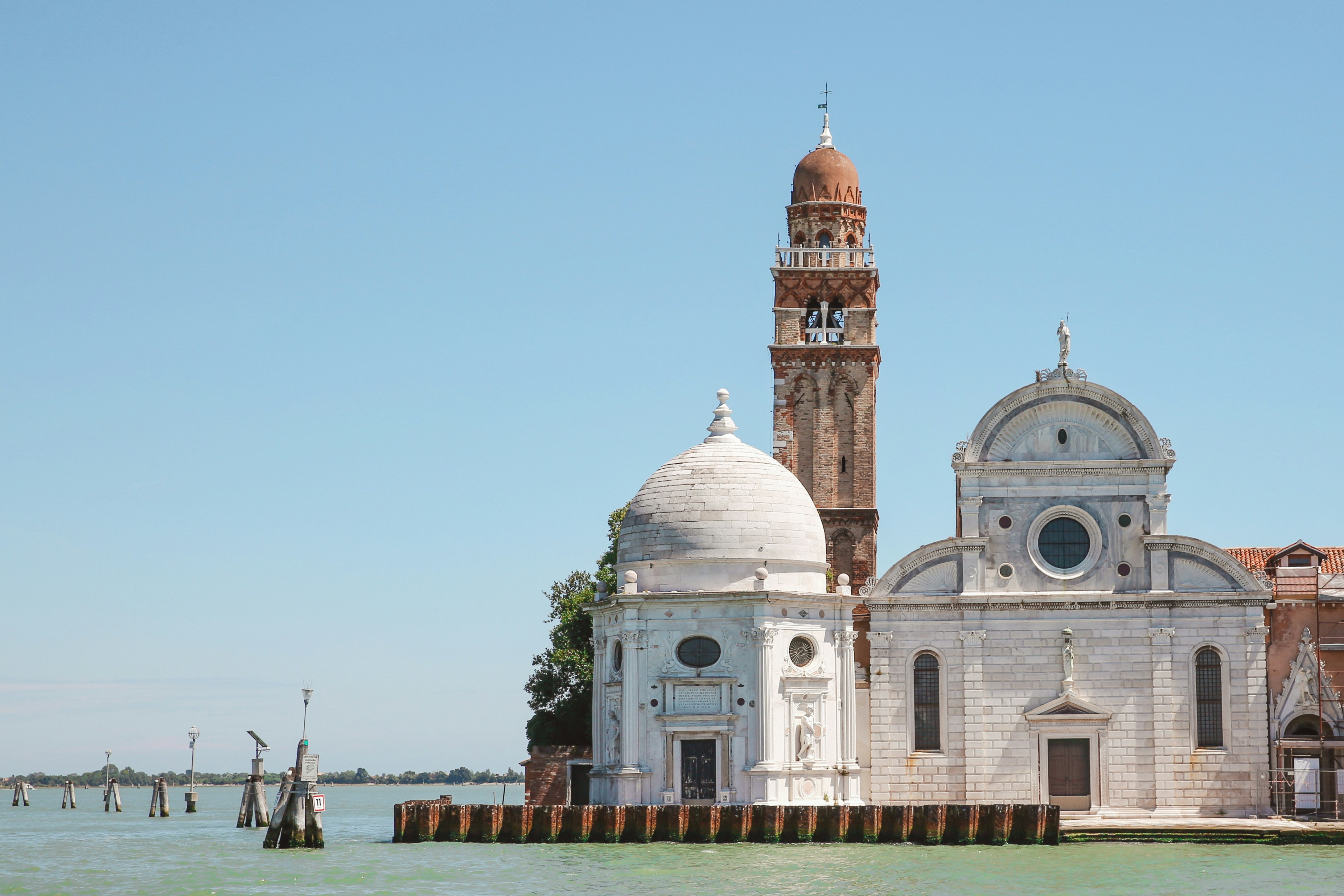 a building with a domed roof by water, San Michele in Isola, a Roman Catholic church, on the Isola di San Michele near Venice.