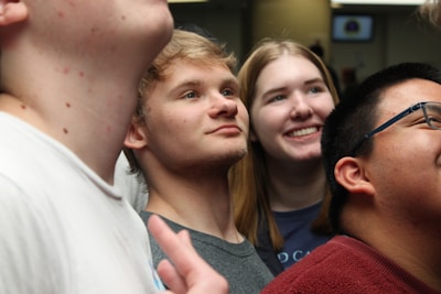 Young people participating in a team-building exercise, supporting each other with bright expressions.