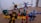 A group of colorful toy robots arranged on a wooden floor, featuring vibrant colors and intricate designs. Each robot is made of interlocking pieces in various poses, showcasing imaginative play. The scene captures a dynamic and playful moment, with toys spread out across the floor.