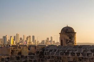 a stone wall with a city in the background