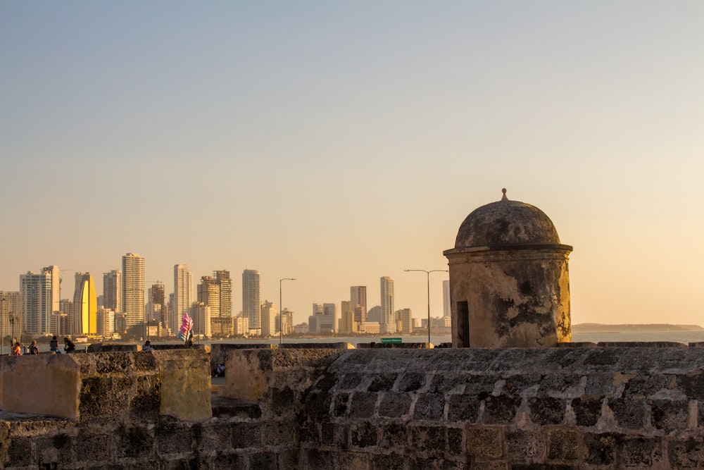 a stone wall with a city in the background