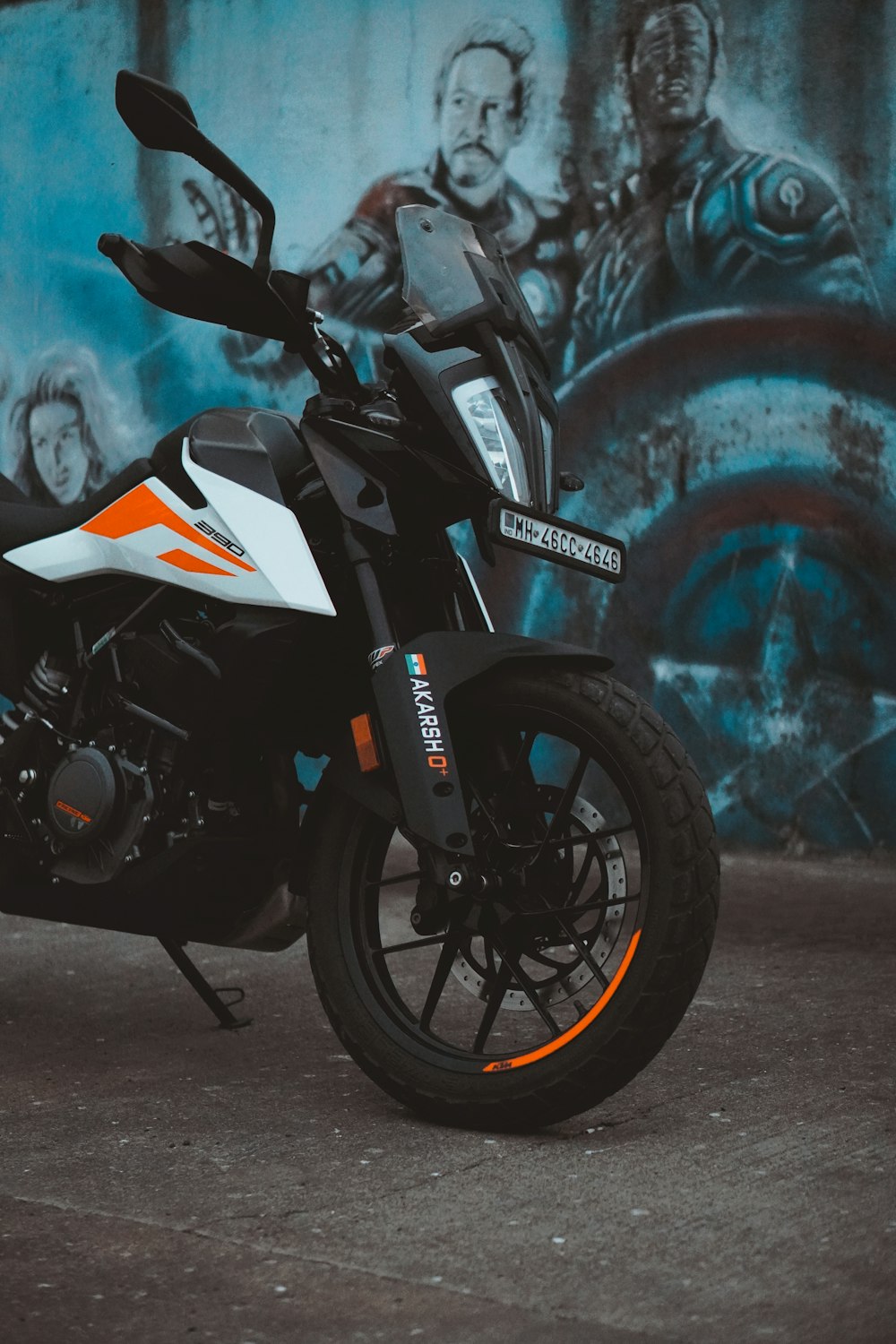 a motorcycle parked in front of a wall with graffiti