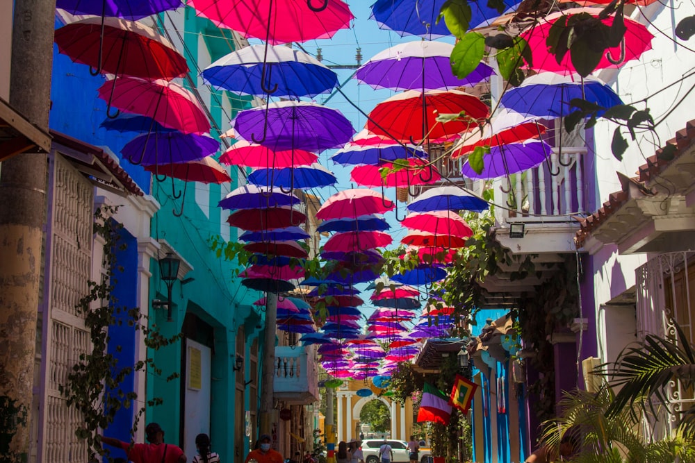 a group of colorful umbrellas swing from a building