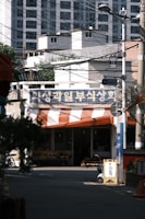 Front view of a small neighborhood grocery store with fresh produce displayed outside.