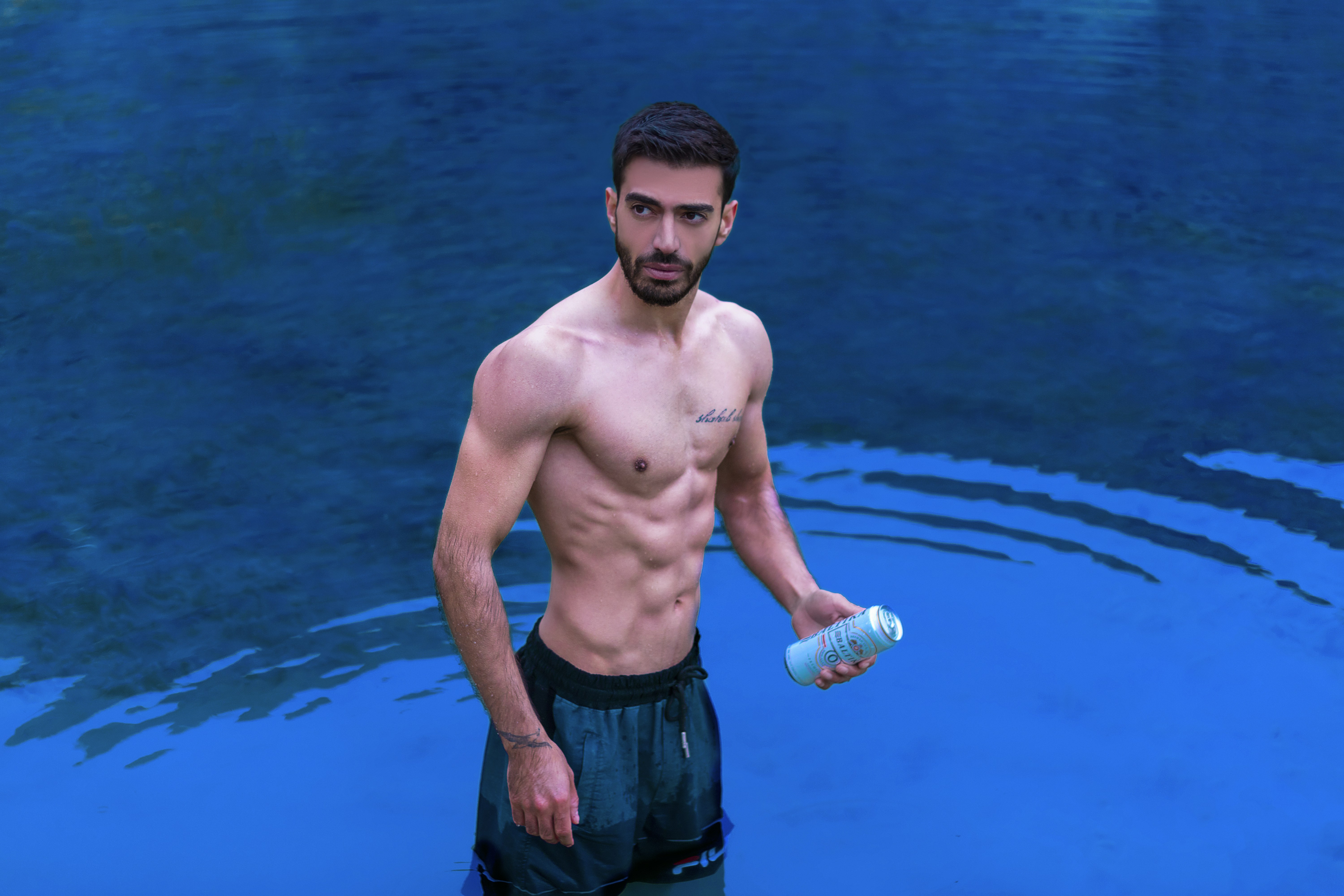 a man in a pool holding a bottle