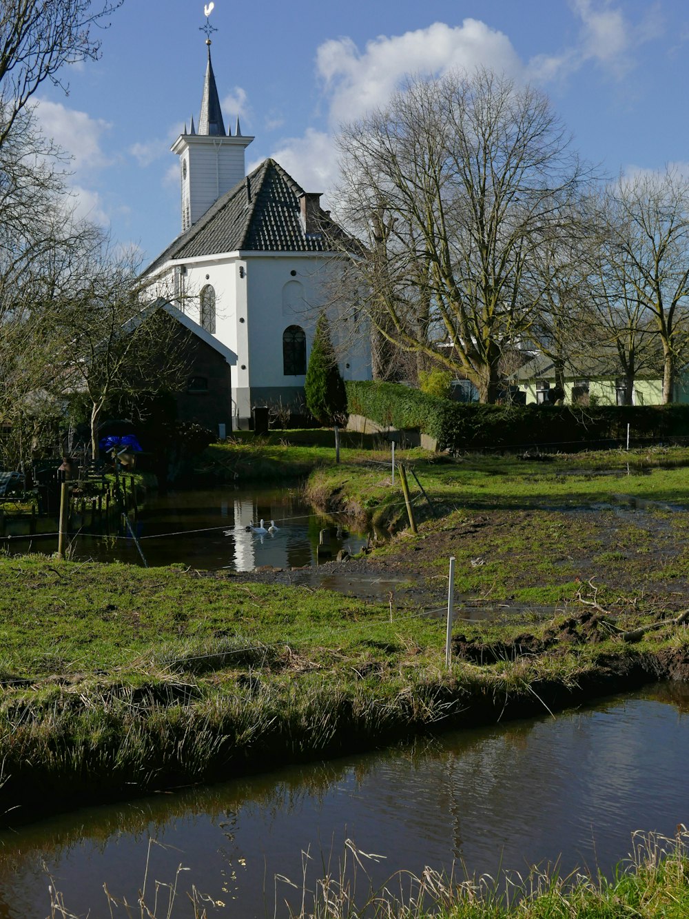 Una iglesia con un estanque frente a ella