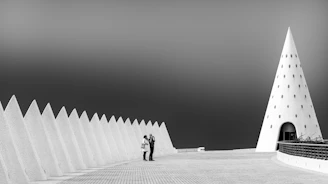 a man and woman standing in front of a pyramid