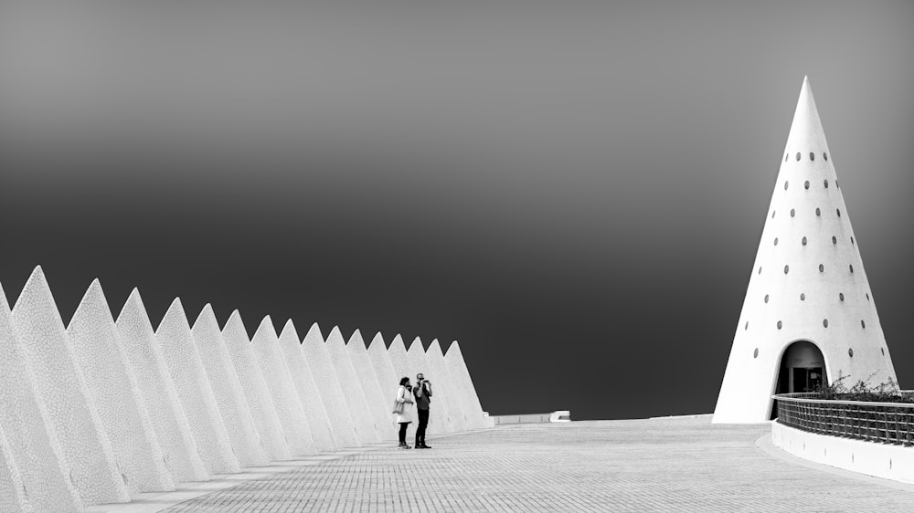 a man and woman standing in front of a pyramid