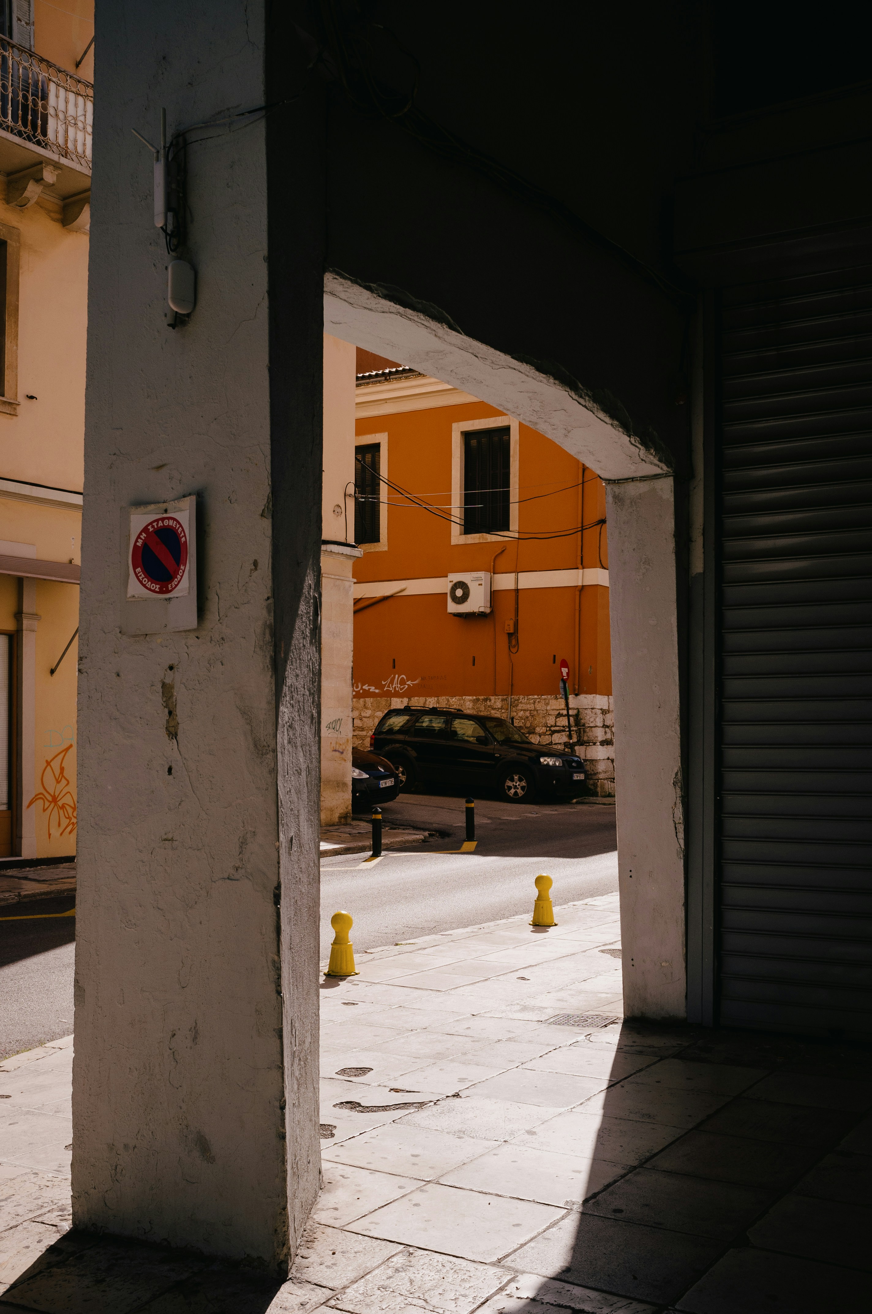 a yellow fire hydrant in a narrow alleyway