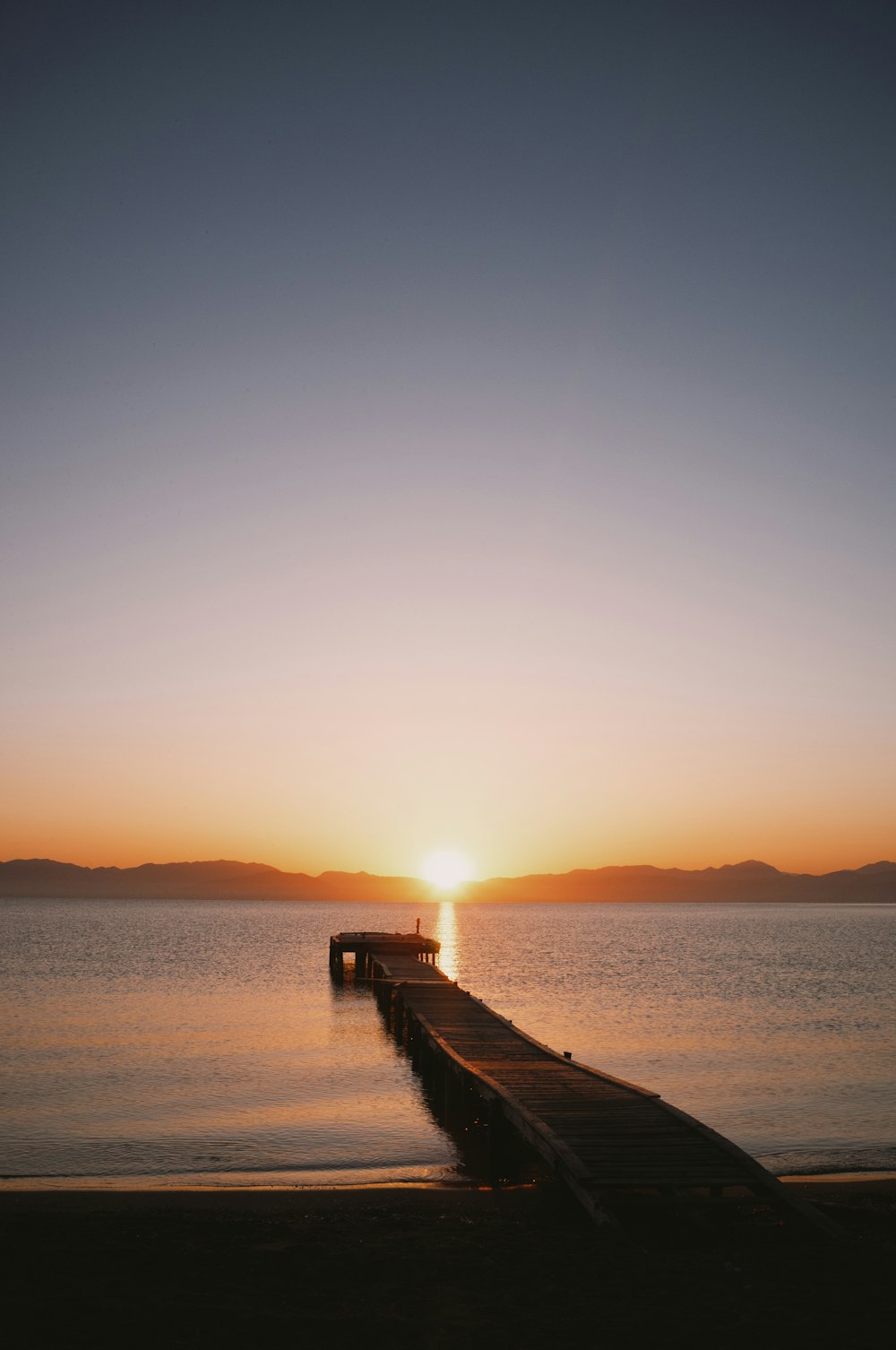 a dock leading out to a sunset