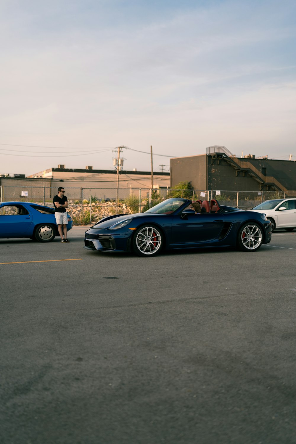 a person standing next to a blue car