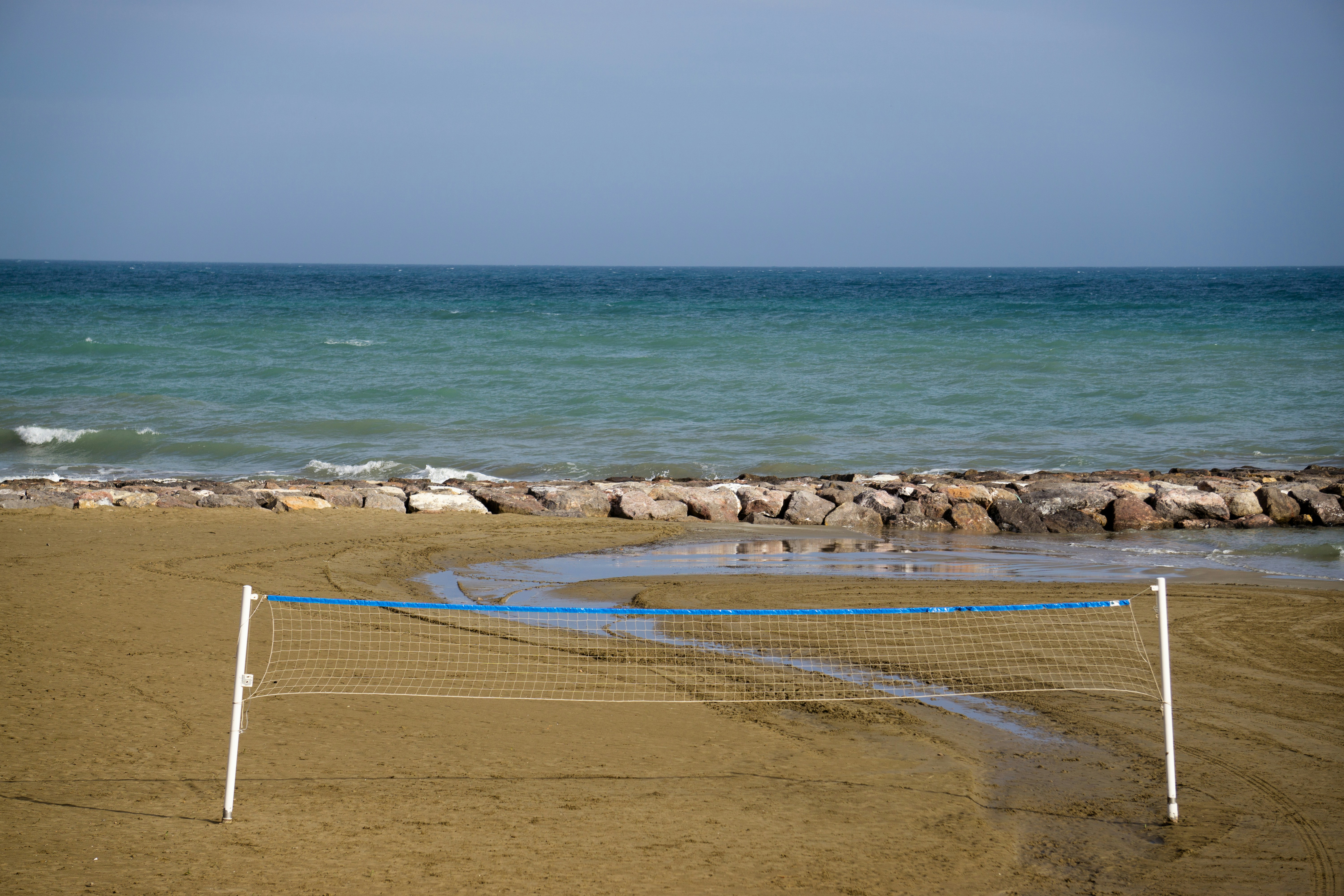 une plage avec une clôture et un plan d’eau