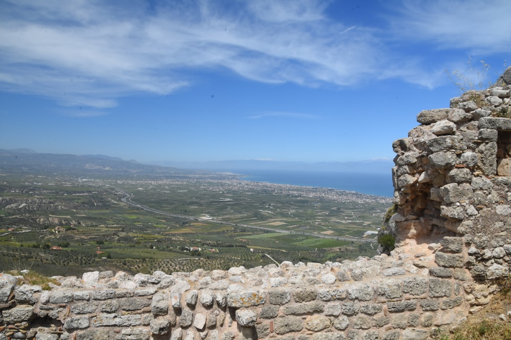 a stone wall with a valley in the background