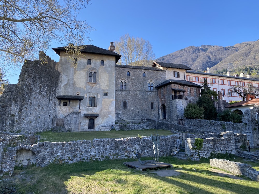 a stone building with a stone wall and a stone wall with a stone wall and a hill with