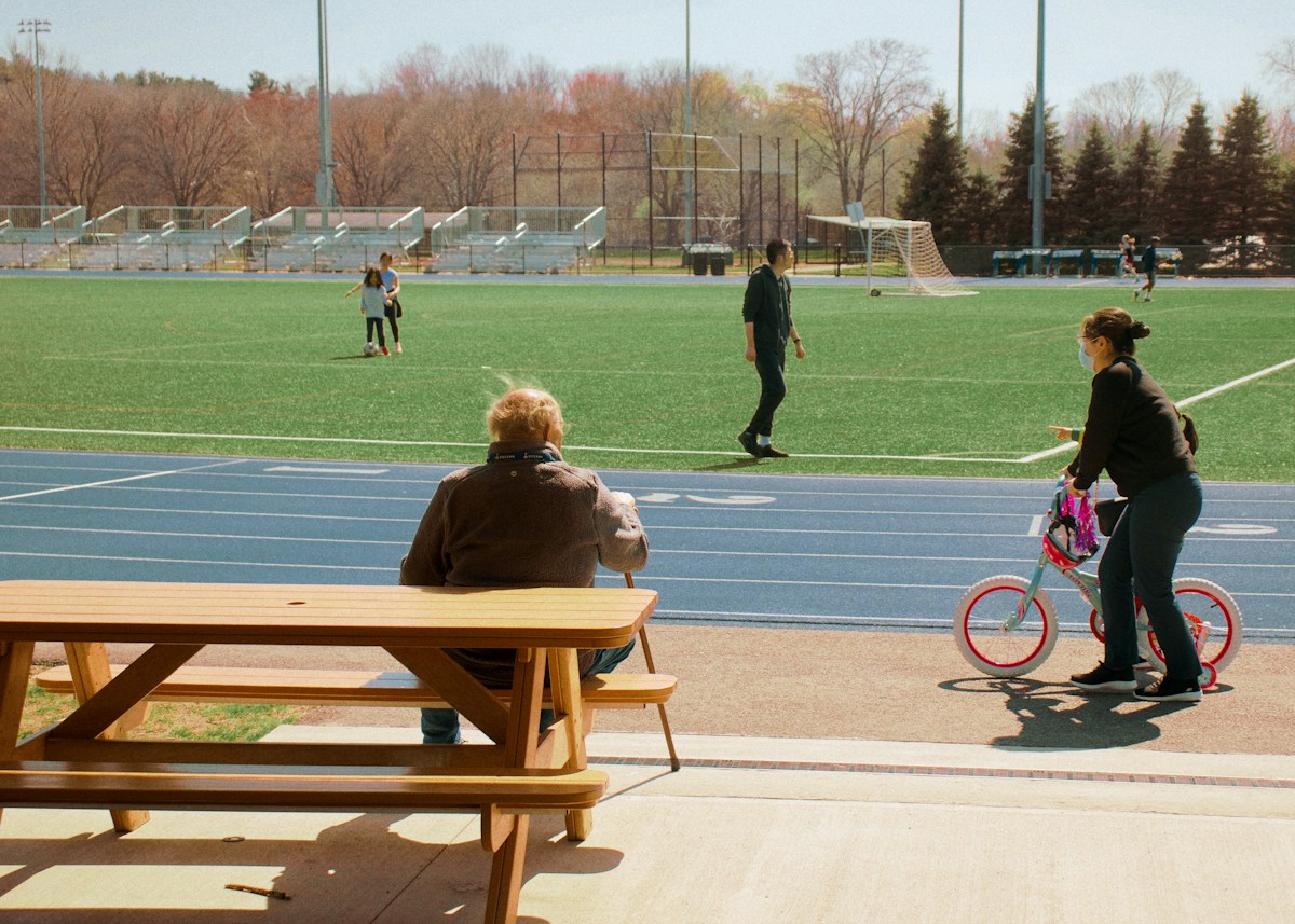 A group of kids playing soccer on a field with parents watching, illustrating youth sports team coordination.