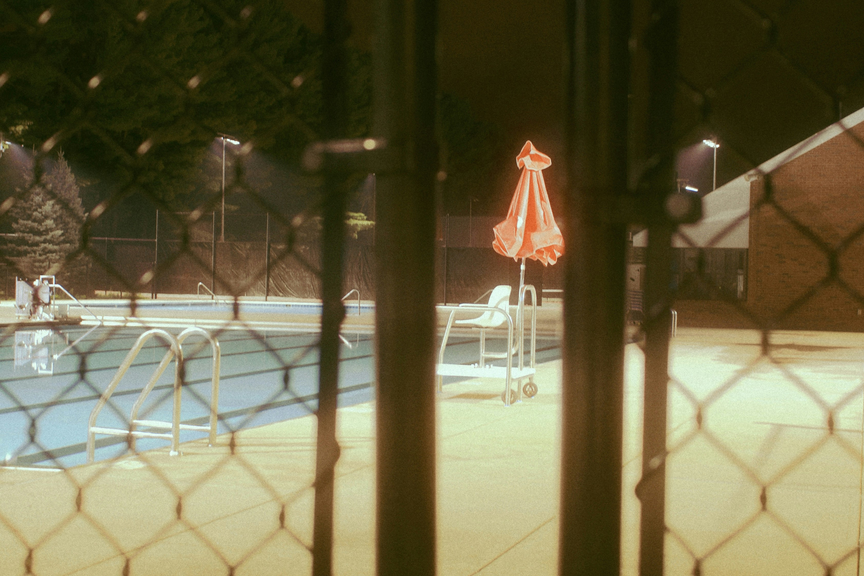 a pool with a red umbrella