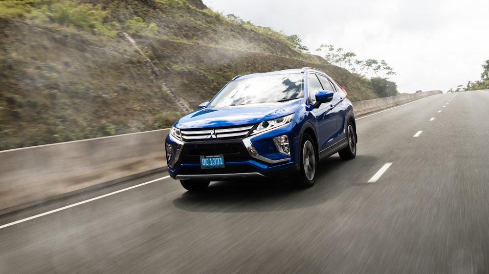 a blue car driving on a road