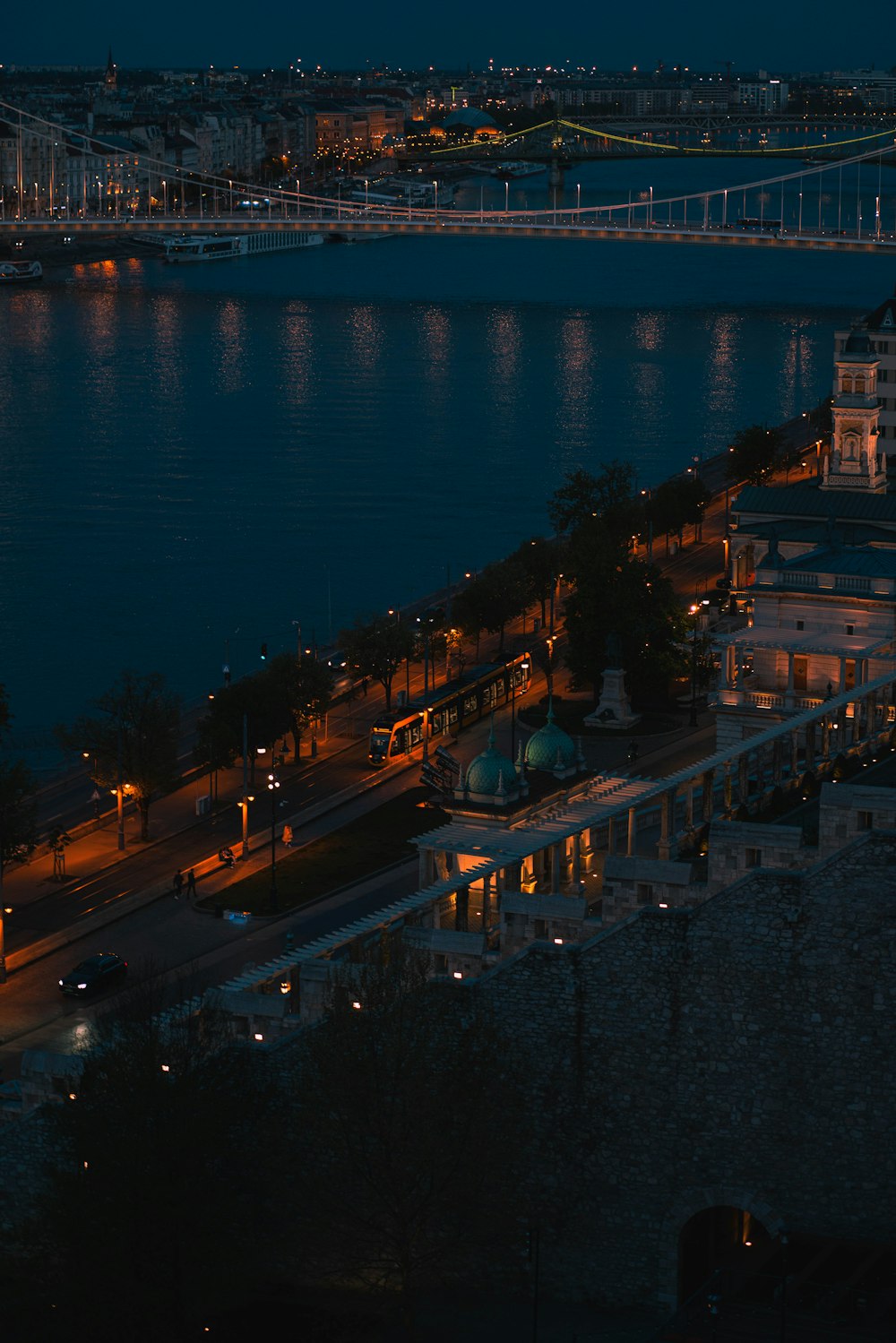 a bridge over a river with buildings and lights at night