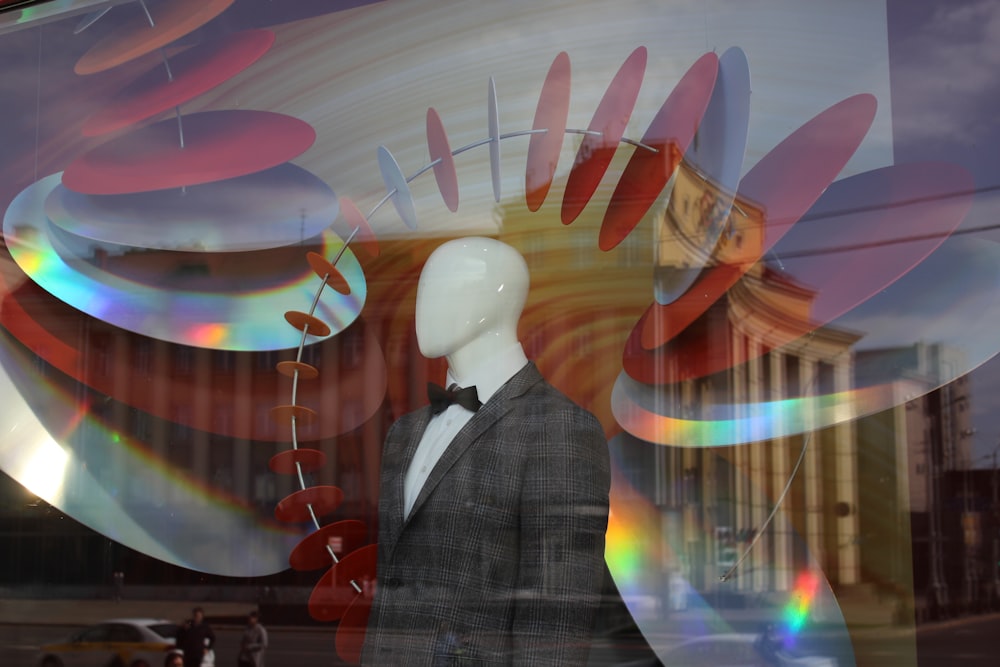 a person wearing a suit and bow tie in front of a large colorful ceiling