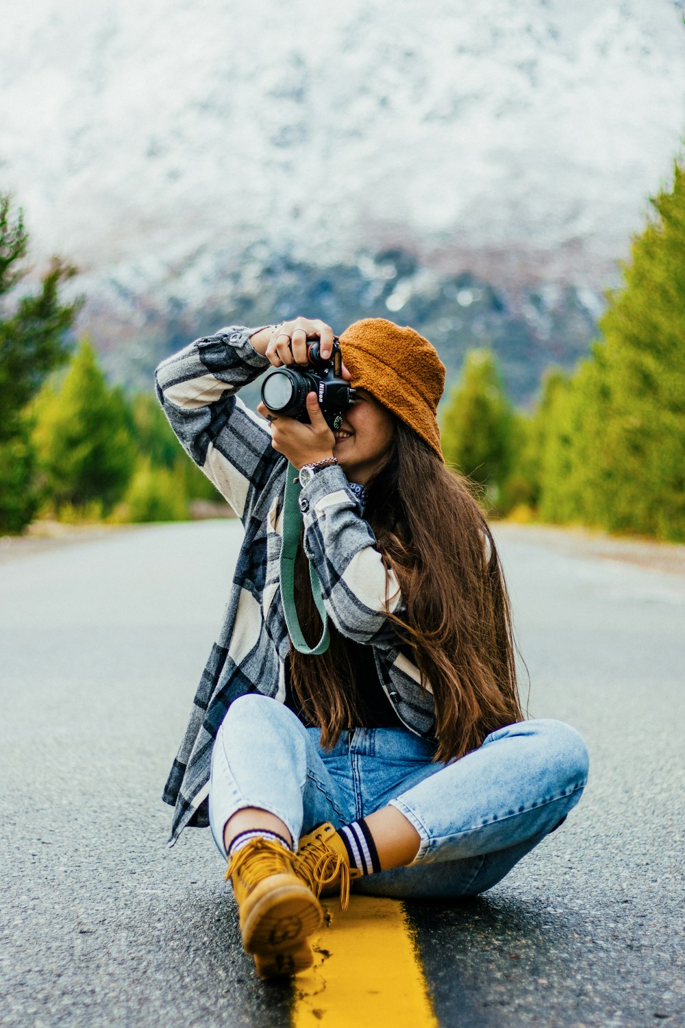 a person sitting on the ground holding a camera