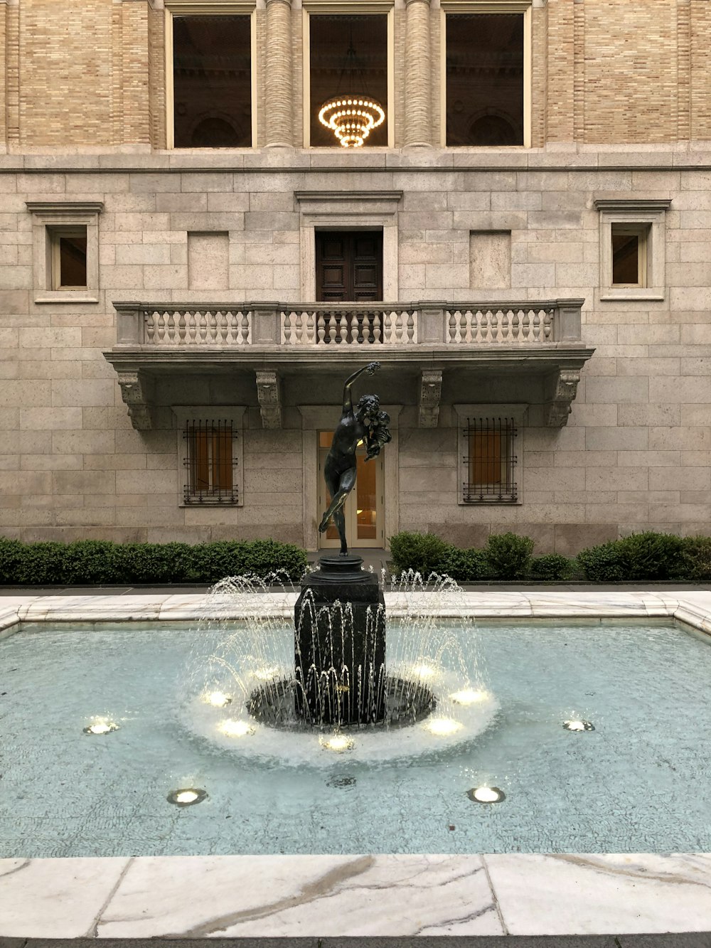 a fountain with a statue in front of a building