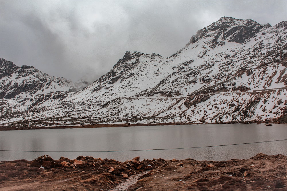 a lake in front of a snowy mountain