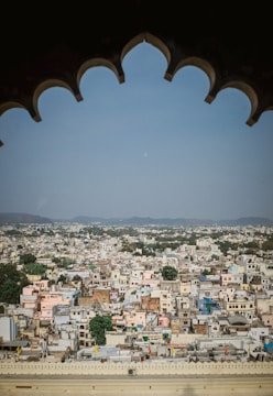 An illustration of a dreamy pastel cityscape with soft pink hues and intricate line work.