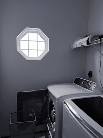 A cozy laundry room featuring a washing machine and dryer perfectly sized for a small niche.