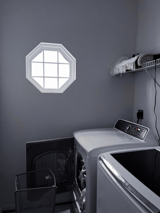 A stylish washing machine in a clean, organized laundry space with fresh towels nearby.