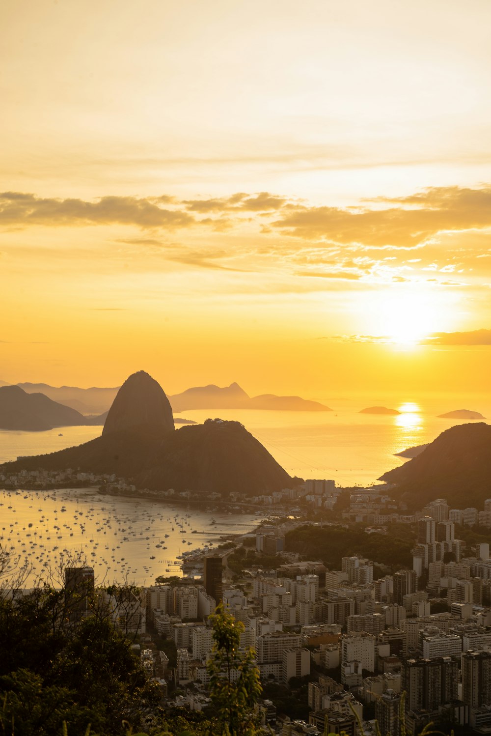 a city with a body of water and mountains in the background