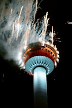 a large tower with fireworks in the background
