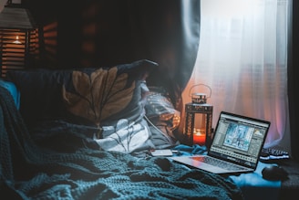 a laptop sits on a bed