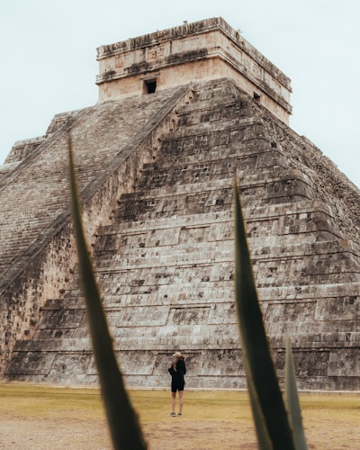 a person standing in front of a large stone building