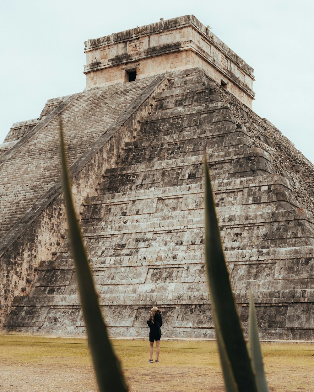 a person standing in front of a large stone building