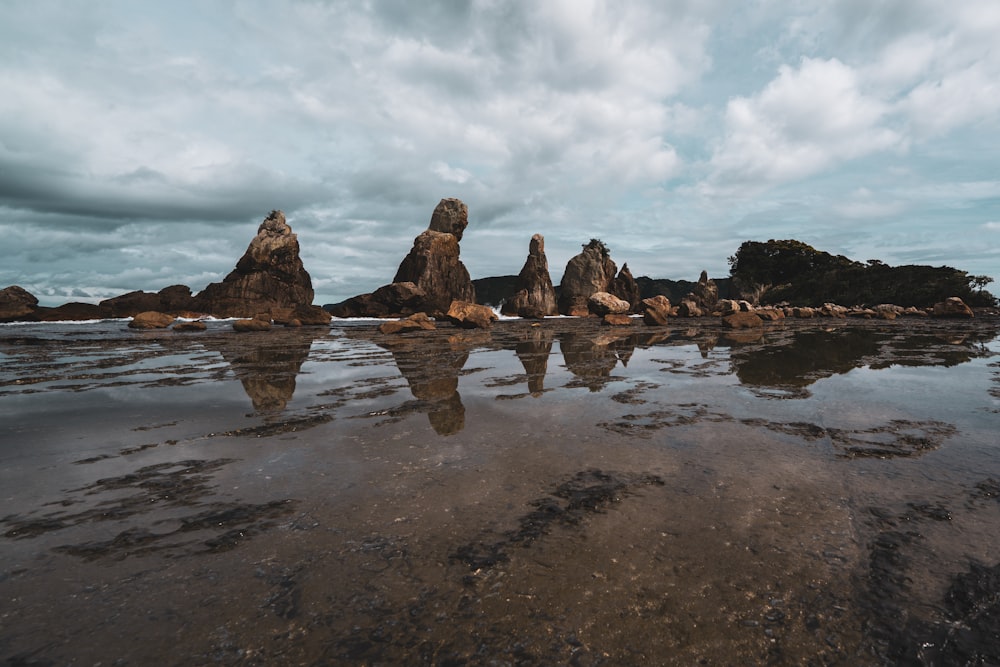 a rocky beach with a few large rocks in the water