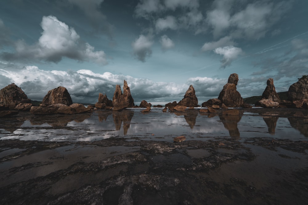 un gruppo di grandi rocce in uno specchio d'acqua