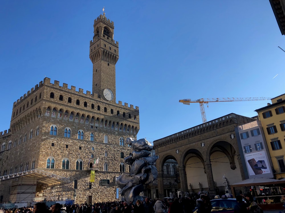 a large building with a clock tower with Palazzo Vecchio in the background
