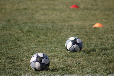a couple of football balls on the grass
