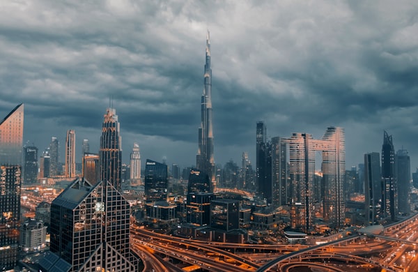 Downtown Dubai office towers glow after dark across the financial district.