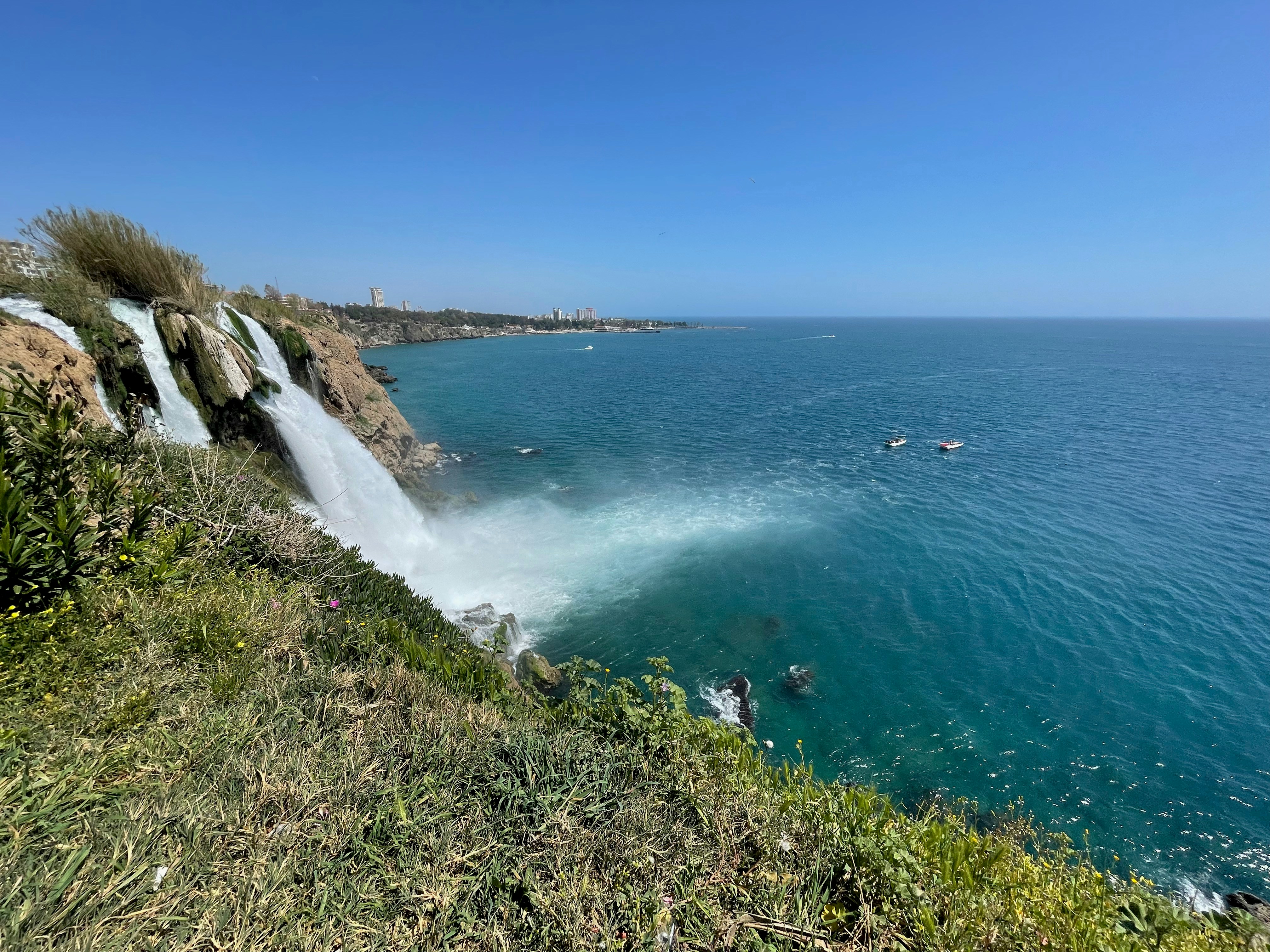 a body of water with rocks and grass on the side